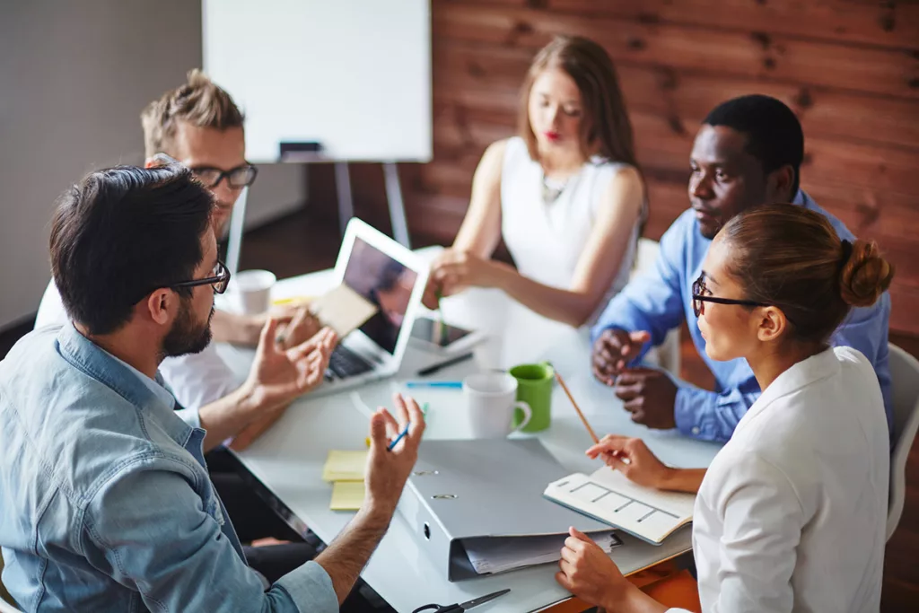 5 people meeting at work listening to one person talking